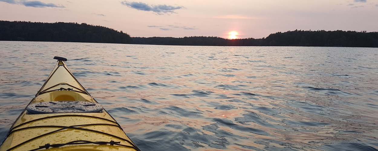 sjö med solnedgång från kajak